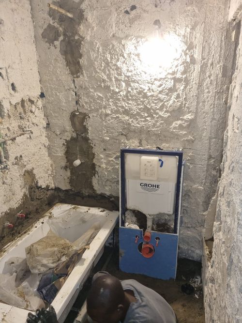 חדר הרחצה באמצע העבודה: קירות חשופים ומיכל הדחה סמוי
